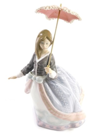 A Lladro figure of a lady holding parasol, number 5211, marked beneath, 16cm high.