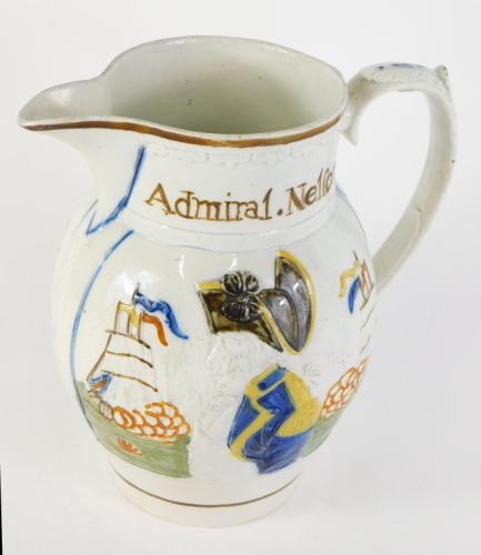 An early 19thC Prattware pearlware Admiral Nelson and Captain Berry jug, raised with flagship and a profile of Nelson with acanthus leaf handle, predominantly in orange, yellow and brown, on a circular foot, 21cm high.