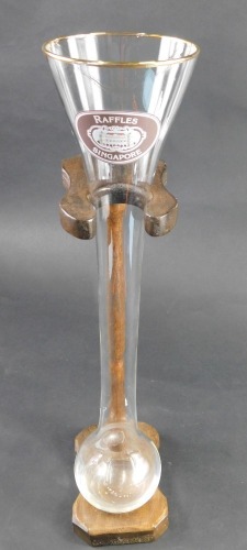 A Raffles Singapore Hotel advertising drinking vessel, on wooden stand, 42cm high.