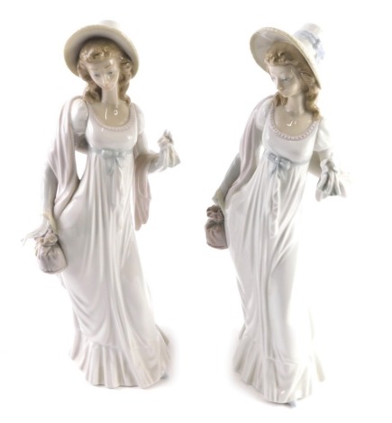 A pair of Lladro Daisa figures of ladies, each in flowing robes wearing hats holding flowers, printed marks beneath, 38cm high. (1 AF)