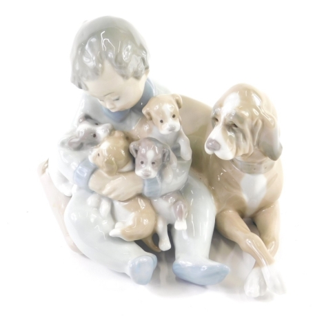 A Lladro figure of child, dog and puppies, S456, printed and impressed marks beneath, 13cm high.