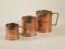 Three graduated copper green measuring cups