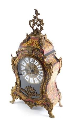 A Continental Boulle table clock, surmounted by a pierced scroll and floral finial, raised above an enamel 15cm Roman numeric dial, and a highly decorative case on scrolled feet with eight day German movement, 52cm high.