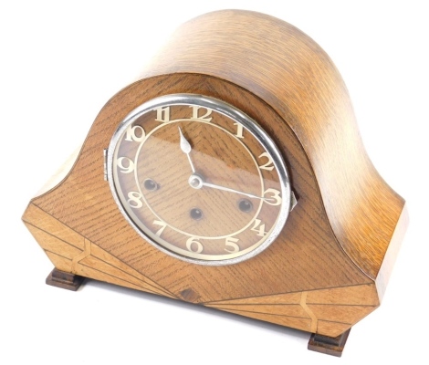 A mid 20thC Art Deco oak chiming mantel clock, with 16cm diameter Arabic dial, in shaped case with eight day chiming movement, 25cm high.