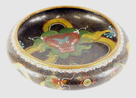 A Chinese cloisonne bowl, the compressed circular body profusely decorated with a dragon, on a black and gilt coloured ground, on circular foot, four character mark beneath, 32cm diameter.