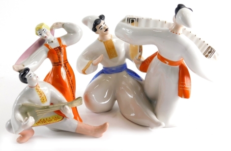 A 20thC Ukrainian porcelain group of two musicians, polychrome decorated in blue and orange, marked beneath 24cm high and another dancing lady and gentleman playing balalaika. (2)