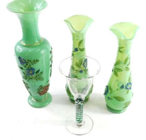 Three green glass vases, each raised with flower picked out in blue, yellow, etc., and a double air twist wine glass, with coloured stem, signed beneath, 21cm high.