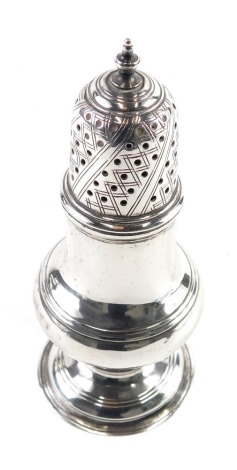 A silver pepper pot, of bellied form with domed pierced lid, urn finial and circular foot, marks rubbed, 11cm high, 1.78oz.