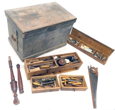 A large early 20thC pine tool chest, of rectangular form containing a large quantity of various tools, leather tape measure, various bits, nails, various lift out drawers containing other tools, the exterior with metal side handles, 60cm high, 97cm wide, 