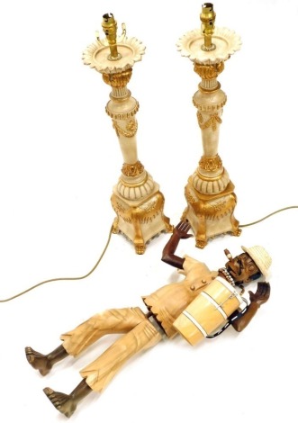 A pair of decorative resin table lamps, each with floral dish holders, acanthus leaf gilt highlighted and garland stems, and shaped scroll feet with modern electrical features, 68cm high, and an articulated figure smoking cigar.