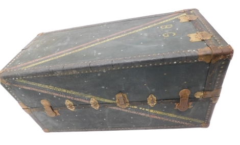 A large metal bound travel trunk, set with various labels, initialled BG and coloured with yellow and red stripes with an outer studding, with keys, 58cm high, 120cm wide, 58cm deep.