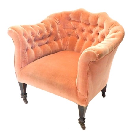 An Edwardian tub chair, upholstered in buttoned pink fabric, on square tapered legs with ceramic castors.