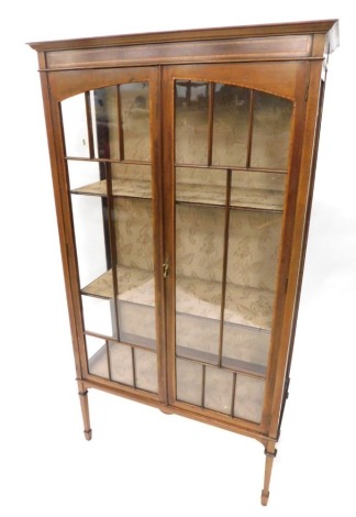 An Edwardian mahogany and satinwood crossbanded display cabinet, with a moulded cornice above two astragal glazed doors enclosing fabric lined shelves, on square tapering legs, 167cm high, 92cm wide.