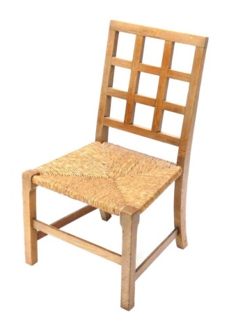 An early 20thC oak rush seated Arts and Crafts child's chair, with lattice back, 69cm high.