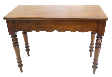 A mahogany side or serving table, of plain form with a shaped apron, on turned tapering legs, 104cm wide.