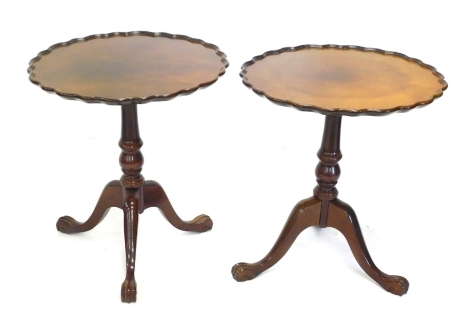 A pair of walnut occasional tables, with pie crust top, on a turned column and tripod base, 67cm high, 60cm diameter.