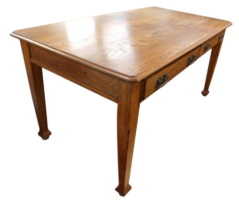 An oak Arts and Crafts style writing table, the rectangular top with a moulded edge above two frieze drawers, each with shaped handles embossed with roundels, on square tapering legs, 152cm wide.