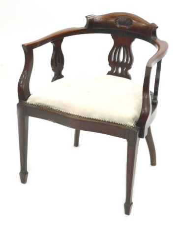 A late 19th/early 20thC mahogany desk chair, with a shaped back carved with a shell, a padded seat with studded brass borders, on square tapering legs.