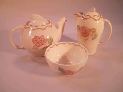 A Susie Cooper tea set of three pieces comprising a tea pot