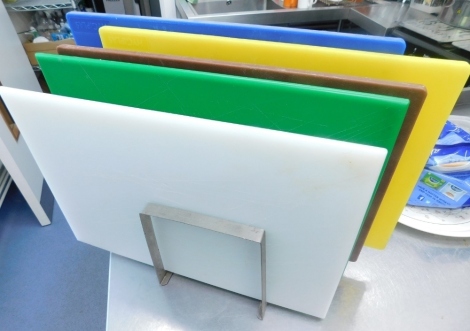 Various catering chopping boards, varying colour on stand, 47cm wide.