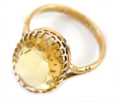 A 9ct gold and citrine ring, with oval claw set stone on part pierced shank, size L.