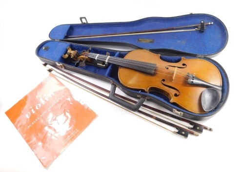 An early 20thC two piece violin, with interior hand written label, Stradivarius Anno 1714, probably German, the main body 35cm long, overall length 62cm, with three bows, in fitted case with violin scales and Arpeggios booklet and other accessories. (a qu