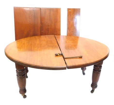 A late Victorian walnut dining table, the oval top with a moulded edge, on part reeded and turned supports with ceramic castors, three loose leaves, 73cm high, 295cm wide extended.