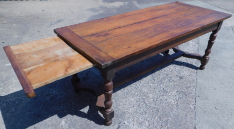 A 19thC Continental fruit wood refectory table, the planked top with cleated ends, on turned supports with H stretcher and bun feet, 76cm high, the top 79cm x 187cm.