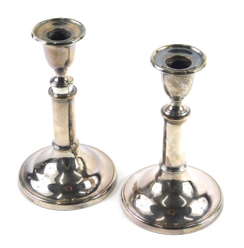 A pair of early 20thC silver plated telescopic candlesticks, with urn dish holders, articulated stems and circular feet, when lowered, 19cm high. (2)