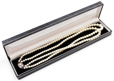 A double strand of Mikimoto graduated cultured pearls, with silver clasp decorated with a raised leaf pattern and additional central pearl, the reserve stamped M, 44cm long overall, largest central pearl 5mm. - 3