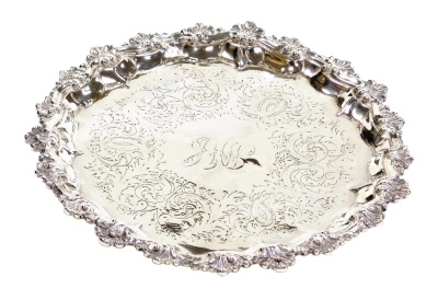 A Victorian silver salver, the centre decorated with monogram surround by floral, leaf and scroll decoration, with a raised piecrust border decorated with shells and scrolls, raised on three ball feet, London 1847, 10.30oz, 20cm diameter.