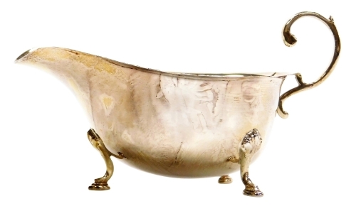 A George V silver sauce boat, with shaped rim and open handle, raised on three hoof supports, Birmingham 1931, 3.32oz, 15cm wide.