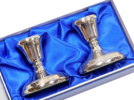 A pair of Elizabeth II silver squat candlesticks, of plain form with raised line decoration, loaded, Birmingham 1989, 7cm high, in fitted box.