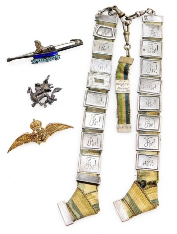 A 9ct gold RAF wings sweetheart brooch, 4.0g, a silver and enamel Lincolnshire Regiment badge, a dragon pendant and a German silver link commemorative belt attachment. (4)