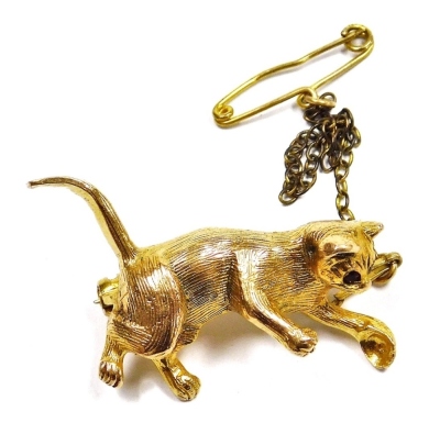 A 9ct gold cat brooch, set with ruby coloured eyes, on a safety chain as fitted, 5.8g.