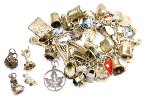 A silver oval link charm bracelet, with forty two silver and white metal charms, English, European and World as fitted, on a bolt ring clasp with safety chain, and five further charms, 100g.