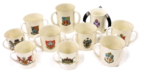 A group of goss tyg form tankards, including Bournemouth, Kingston on Hull, Brighton and Norfolk, together with a tyg form tankard with tusk form handles, presented by the Society of Miniature Rifle Clubs for Skill in Rifle Shooting. (10)