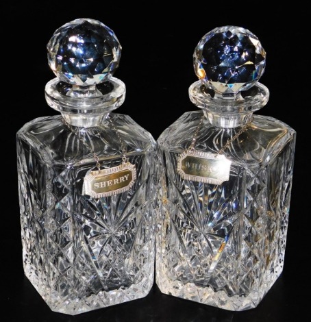 A pair of cut glass decanters and stoppers, with silvered decanter labels engraved for whisky and sherry, Birmingham 1994 and 1996.