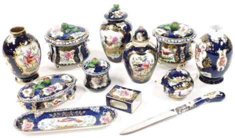 A group of late 19thC Booths Blue Scale pattern vases and dressing table wares, decorated with reserves of exotic birds and flowers, comprising four vases, two with covers, four dressing table jars and covers, with floral finials, a match sleeve, miniatur