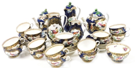 A late 19thC Booths Blue Scale ground tea service, decorated with reserves of exotic birds and flowers, comprising two teapots, two water jugs, one with cover, sugar bowl, cream jug, fifteen teacups and thirteen saucers.