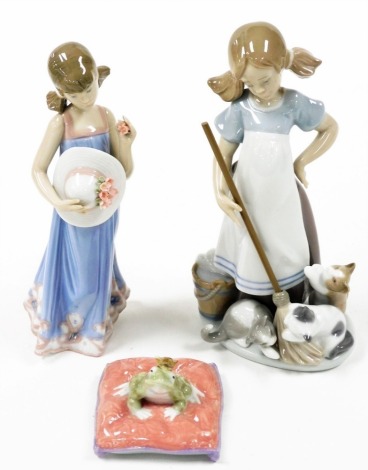 A Lladro porcelain figure, modelled as a girl with a bonnet, 5648, another figure of a girl with kittens, 5232, and a figure of Enchanted Prince, a frog on a cushion, boxed. (3)