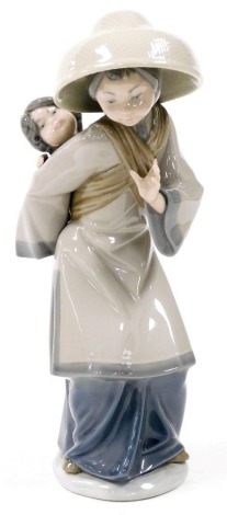 A Lladro porcelain figure of an Oriental mother and child, 26cm high.