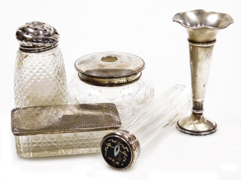 A group of cut glass and silver mounted dressing table jars and bottles, to include a cylindrical long stem faceted bottle with silver tortoiseshell and mother of pearl inlaid lid, London 1911, 16cm high, cylindrical cut glass and silver mounted dressing 