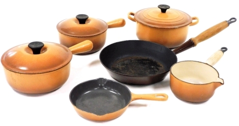 A group of Le Creuset lidded saucepans, in brown, comprising two saucepans, 20cm diameter and 18cm diameter, milk pan with wooden handle, 15cm wide, double lipped frying pan, 18cm diameter, two handled casserole pot, 21cm diameter, and frying pan with woo