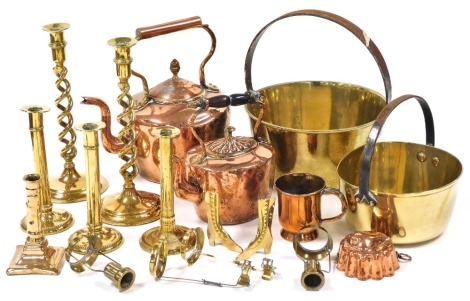 A group of brass and copper ware, to include a copper kettle, 30cm high, pair of brass candlesticks with spiral turned column, 30cm high, two preserve pans, copper jelly mould, other candlesticks, etc. (1 box)