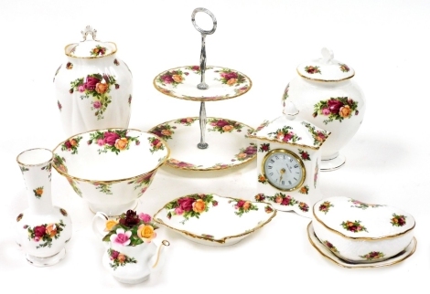 A group of Royal Crown Derby Old Country Rose pattern wares, to include a two tier cake stand, 26cm high, heart shaped lidded trinket dish, 13cm high, mantel clock with Roman numeric dial, 15cm high, jar and cover, 24cm high, etc. (1 tray)