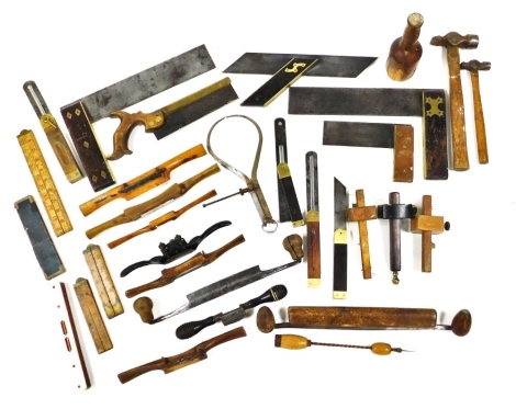 Vintage tools, including spokeshaves, squares, calipers, rulers, mortise gauges, and a level.