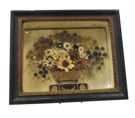 A Georgian seed work collage, showing a basket of flowers of a plinth, cased and glazed, with label to back stating 'This Arrangement of Seeds was Made in 1819 by Eliza Walter for Lady Grey de Ruthyn Not in Consideration for High Rank; but as a Tribute of