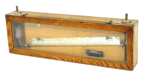 A Negretti and Zambra liquid gauge, GR.0.785, cased, 48cm wide.