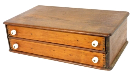 An early 20thC mahogany collectors or haberdashery chest, of two long drawers with ceramic knob handles, 54cm wide, 31cm deep.